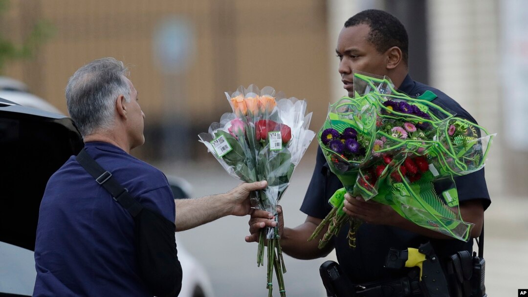 Seorang polisi di Dallas, Texas menerima bunga tanda simpati dari seorang warga, pasca insiden penembakan polisi di sana (9/7). 