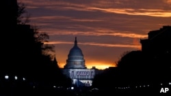 FILE - The U.S. Capitol Building is illuminated during sunrise in Washington.