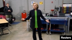 Hillary Clinton talks to reporters in an auto shop as she campaigns for the 2016 Democratic presidential nomination at Kirkwood Community College in Monticello, Iowa, April 14, 2015. 