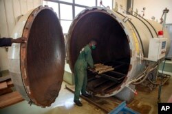 FILE—A worker puts bamboo sticks into a dryer at a factory in Wakiso, Uganda on March 13, 2024.