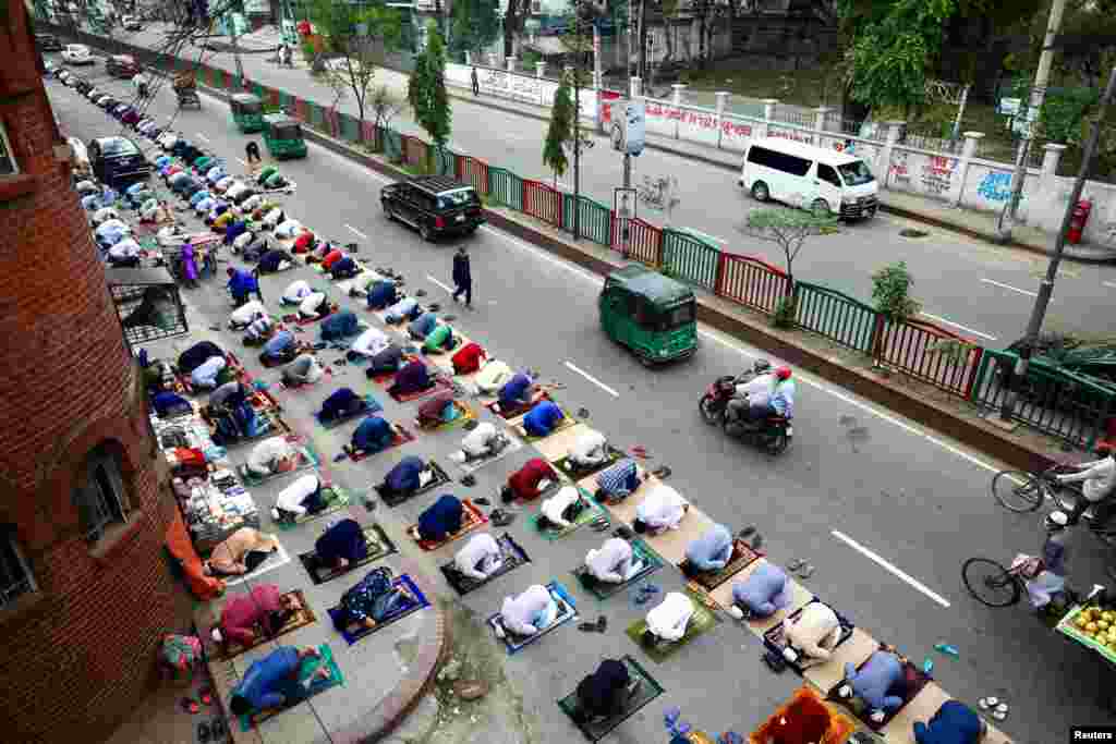 Muslims attend the Friday prayer on the street during the holy month of Ramadan amid concerns over the coronavirus disease outbreak in Dhaka, Bangladesh.