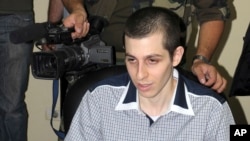 BESTAND - Een cameraman van Hamas staat achter de Israëlische soldaat Gilad Schalit, vrijgelaten na meer dan vijf jaar gevangenschap, aan de Egyptische kant van de grensovergang bij Rafah op 18 oktober 2011.