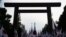 FILE - Members of nationalist movement "Ganbare Nippon" raise Japanese national flags towards the huge Torii gate at the Yasukuni shrine.