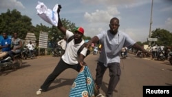 People celebrate the departure of Burkina Faso's ex-President Blaise Compaore by burning fabric with his political party's logo, in Ouagadougou, capital of Burkina Faso, October 31, 2014. General Honore Traore, the head of Burkina Faso's armed forces, too