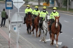 Mounted police, wearing protective face masks as a precaution against the spread of the new coronavirus, patrol the streets of Soacha, on the outskirts of Bogota, Colombia, April 1, 2020, during a countrywide lockdown.