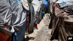 A boy from the community who call themselves the "Muhammasheen," or "the Marginalized," stands near his hut in a slum area of Sanaa, Yemen, April 16, 2016.