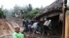 Men look inside a home that was buried after a landslide in the town of Santa Maria de Tlahuitoltepec, Mexico, 28 Sep 2010