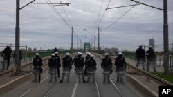 Serbian police officers guard Old Sava Bridge, which is closed for removal, in Belgrade, Serbia, Nov. 20, 2024.