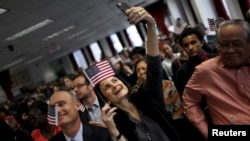 A new U.S. citizen takes a selfie after taking the Oath of Allegiance during a special naturalization ceremony at the U.S. Citizenship and Immigration Services District Office in New York City, Nov. 13, 2015. REUTERS/Mike Segar