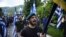 FILE - In this June 17, 2018 file photo, opponents of the deal between Greece and Macedonia on the latter country's new name - North Macedonia - hold Greek flags as they protest in northern Greece. Greece has moved to expel two Russian diplomats over allegations that organizations allegedly received Russian money to protest the agreement.