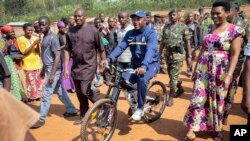 Pierre Nkurunziza, le président sortant du Burundi, se rend à vélo au bureau de vote, accopagné de sa femme et de ses partisans, dans son village natal de Ngozi, au Burundi, le 21 juillet 2015.