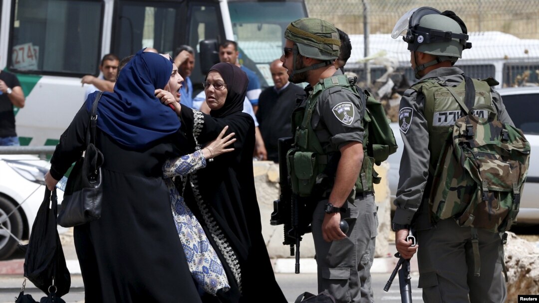 Seorang perempuan berdebat dengan polisi di dekat lokasi tertembaknya dua warga Palestina dekat pos penjagaan Qalandia, Ramallah, Tepi Barat (27/4).