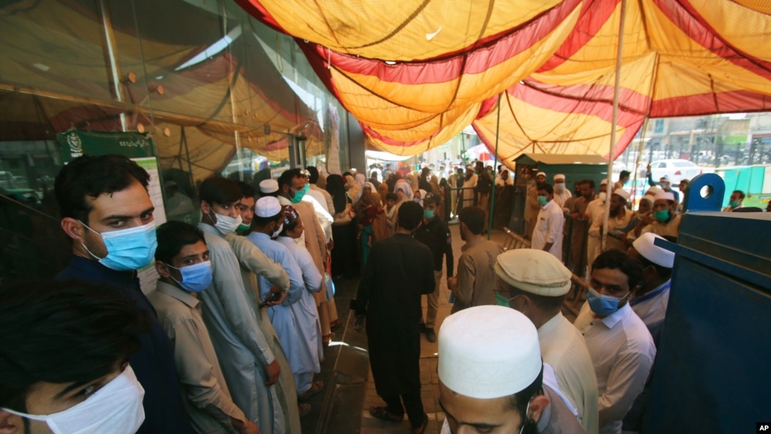 People stand outside a government office to get their identity cards verified to receive aid from the government during a nationwide lockdown to try to contain the outbreak of the coronavirus, in Peshawar, Pakistan, June 16, 2020. 