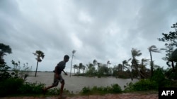 A boy runs along an embankment ahead of the expected landfall of Cyclone Amphan, in Dacope, Bangladesh, May 20, 2020. Amphan was downgraded to a tropical depression Wednesday but was still expected to drench parts of inland India and Bangladesh. 