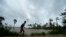A boy runs along an embankment ahead of the expected landfall of Cyclone Amphan, in Dacope, Bangladesh, May 20, 2020. Amphan was downgraded to a tropical depression Wednesday but was still expected to drench parts of inland India and Bangladesh. 