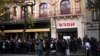 FILE - People stand in front of the Bataclan concert venue during ceremonies across Paris marking the second anniversary of the terror attacks of November 2015 in which 130 people were killed, in the French capital, Nov. 13, 2017. Rapper Medine's scheduled concerts at the Bataclan have caused controversy. 