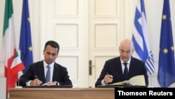 El canciller italiano, Luigi Di Maio, y su homólogo griego, Nikos Dendias, firman el tratado en la sede del ministerio de Exteriores, en Atenas, Grecia.