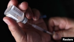 A nurse prepares a H1N1 influenza vaccine during the start of a campaign against the influenza at a hospital in Tegucigalpa March 23, 2010. There have been 18 deaths since the arrival of the virus in the country, according to Honduras Ministry of Health. 