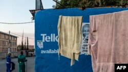 FILE - People walk past an African National Congress (ANC) poster in the run up to May 8 elections in Johannesburg, April 28, 2019.