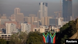 FILE - A general view of Pretoria's skyline with South African flags displayed on a lamp post are seen in Pretoria, South Africa, June 19, 2024.