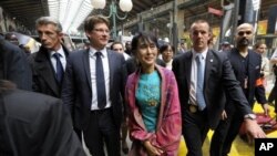 Aung San Suu Kyi (tengah) saat tiba di stasiun kereta api Gare du Nord di Paris, Selasa (26/6).