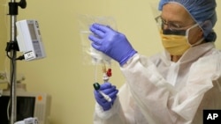 FILE - A nurse practitioner prepares to start the first human gene editing treatment for Hunter syndrome, an inherited metabolic disease, at a hospital in Oakland, Calif., Nov. 13, 2017. 