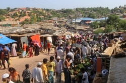 In this May 15, 2020, photo, Rohingya refugees shop for vegetables at Kutupalong Rohingya camp bazar in Cox’s Bazar, Bangladesh.