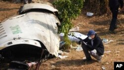 A French investigator takes a photo of the wreckage of a passenger plane at the crash site, in Pokhara, Nepal, Jan.18, 2023. 
