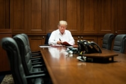FILE - President Donald Trump works in his conference room at Walter Reed National Military Medical Center in Bethesda, Maryland, Oct. 3, 2020, after testing positive for COVID-19. (Official White House Photo by Joyce N. Boghosian)