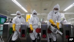 Trabalhadores usam máscaras e fatos de proteção devido ao coronavírus na Coreia do Sul. Seul, 28 fevereiro, 2020