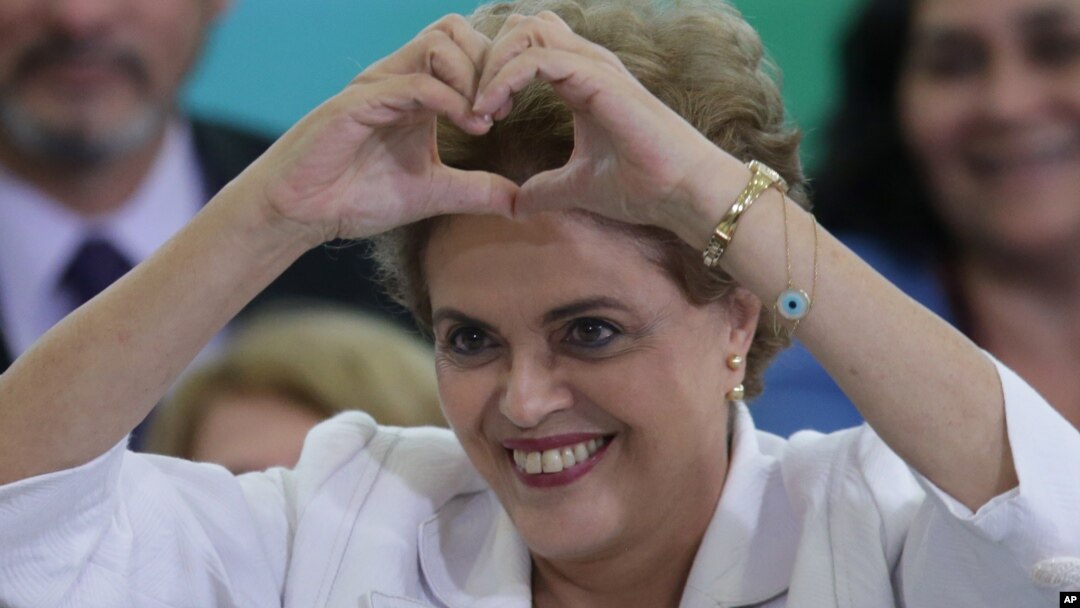 Presiden Brazil Dilma Rousseff membuat tanda hati (cinta) dengan tangannya pada pertemuan dengan guru dan pelajar di Brasilia, Brazil (12/4).