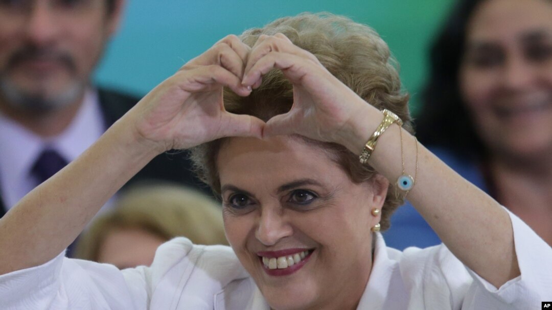 Brazil's President Dilma Rousseff makes a heart sign during a ceremony with teachers and students at Planalto presidential palace in Brasilia, Brazil, Tuesday, April 12, 2016. 