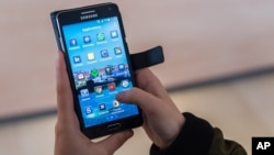 FILE - A woman uses an Android smartphone in Brussels, April 20, 2016. The European Union on Wednesday gave the U.S. two months to name a data protection ombudsman under the 2016 Privacy Shield.