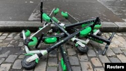 FILE - Dock-free electric scooters Lime-S by California-based bicycle sharing service Lime are stacked on Parisian cobblestones in a street of Paris, France, May 19, 2019. 