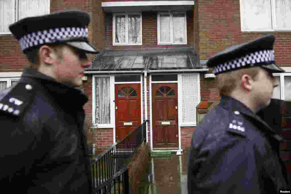 Two police officers walk outside a flat in London, February 26, 2015. Local media reported that the flat is the former home of Mohammed Emwazi, whom investigators believe is the &quot;Jihadi John&quot; masked fighter who fronted the Islamic State militant beheading videos.