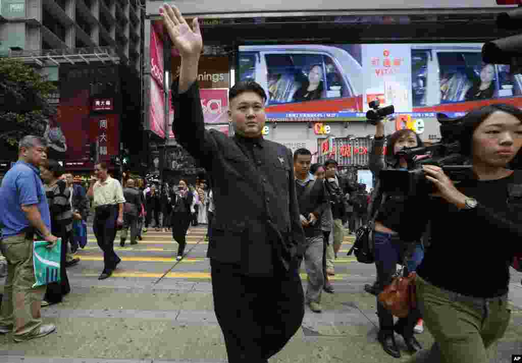 Howar, musisi Hong-Kong berusia 35 tahun, memakai pakaian dan model rambut seperti pemimpin Korea Utara Kim Jong Un, berjalan di pusat kota Hong Kong. 