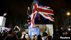 People celebrate at the statue of Winston Churchill as Britain leaves the EU on Brexit day in London, Britain, January 31, 2020. REUTERS/Henry Nicholls