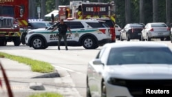 A police officer gestures as agents investigate reports of shots fired outside Republican presidential nominee and former U.S. President Donald Trump's Trump International Golf Course in West Palm Beach, Florida, Sept. 15, 2024. 