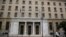 FILE - People walk past the Bank of Greece headquarters, in central Athens, March 27, 2015. 