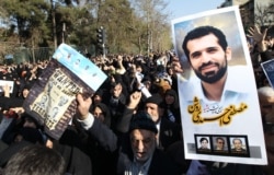 Iranians hold a portrait of assassinated nuclear scientist Mostafa Ahmadi Roshan during his funeral after the Friday prayers outside Tehran university on Jan. 13, 2012.