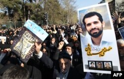 Iranians hold a portrait of assassinated nuclear scientist Mostafa Ahmadi Roshan during his funeral after the Friday prayers outside Tehran university on Jan. 13, 2012.