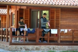 FILE - Venezuelan refugees, 8-month pregnant Stephanie Paez and her partner Kervin Leiva, hang clothes to dry outside their bungalow in La Ciguena holiday complex amid the coronavirus (COVID-19) outbreak in Arganda del Rey, Spain, April 3, 2020.