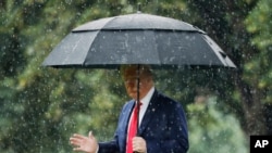 President Donald Trump walks in the rain on the South Lawn of the White House in Washington, June 11, 2020, before boarding Marine One for a short trip to Andrews Air Force Base, Md., and then on to Dallas. 