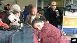 Passengers wait under large tent set-up in the parking lot outside Cairo's International airport as Egyptians and foreigners prepare to leave Egypt, February 1, 2011