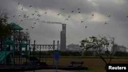 FILE - A portion of the Cheniere Texas LNG facility is seen from a playground near a residential neighborhood in Portland, Texas, June 13, 2022.