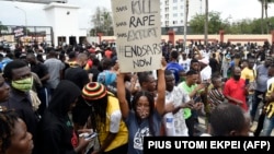 Une femme tient une pancarte lors d'une manifestation en cours pour appeler à la démolition de l'unité de police controversée à Ikeja, le 9 octobre 2020.