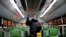FILE - A worker disinfects a public bus against coronavirus in Tehran, Iran, Feb. 26, 2020. 
