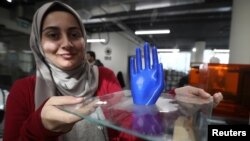 An employee shows a 3D-printed prosthetic hand, created at the FabLab in city of Irbid, Jordan, Feb. 26, 2019. 