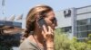 Una mujer habla por su celular mientras pasa frente al edificio que alberga al grupo israelí NSO, fabricante del software espía Pegasus, en Herzliya, cerca Tel Aviv, el 28 de agosto de 2016.