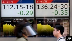 People walk by an electronic board displays exchange rate of euro, left, and British pound at the securities firm in Tokyo, Monday, June 27, 2016.